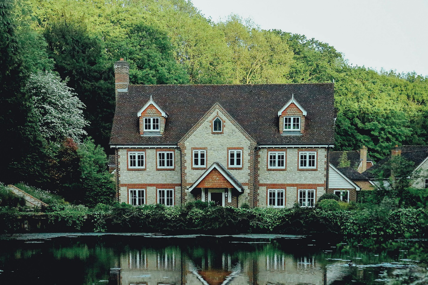 A manor with a lake in the front.