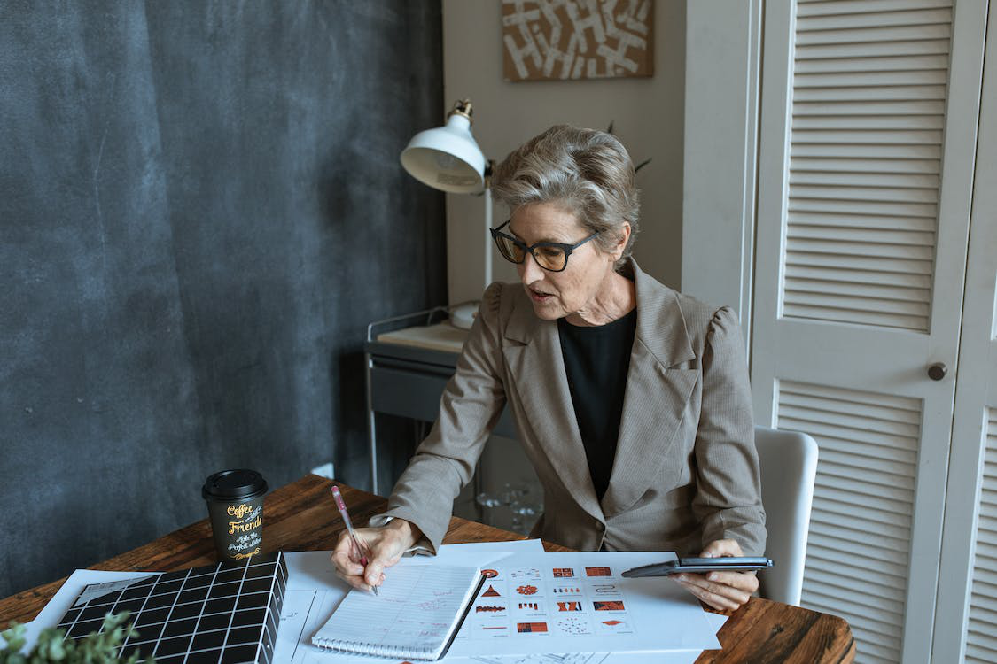 A woman writing in a notebook while working