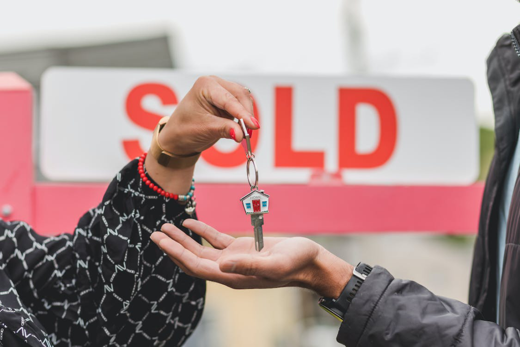 A person handing over keys to another person